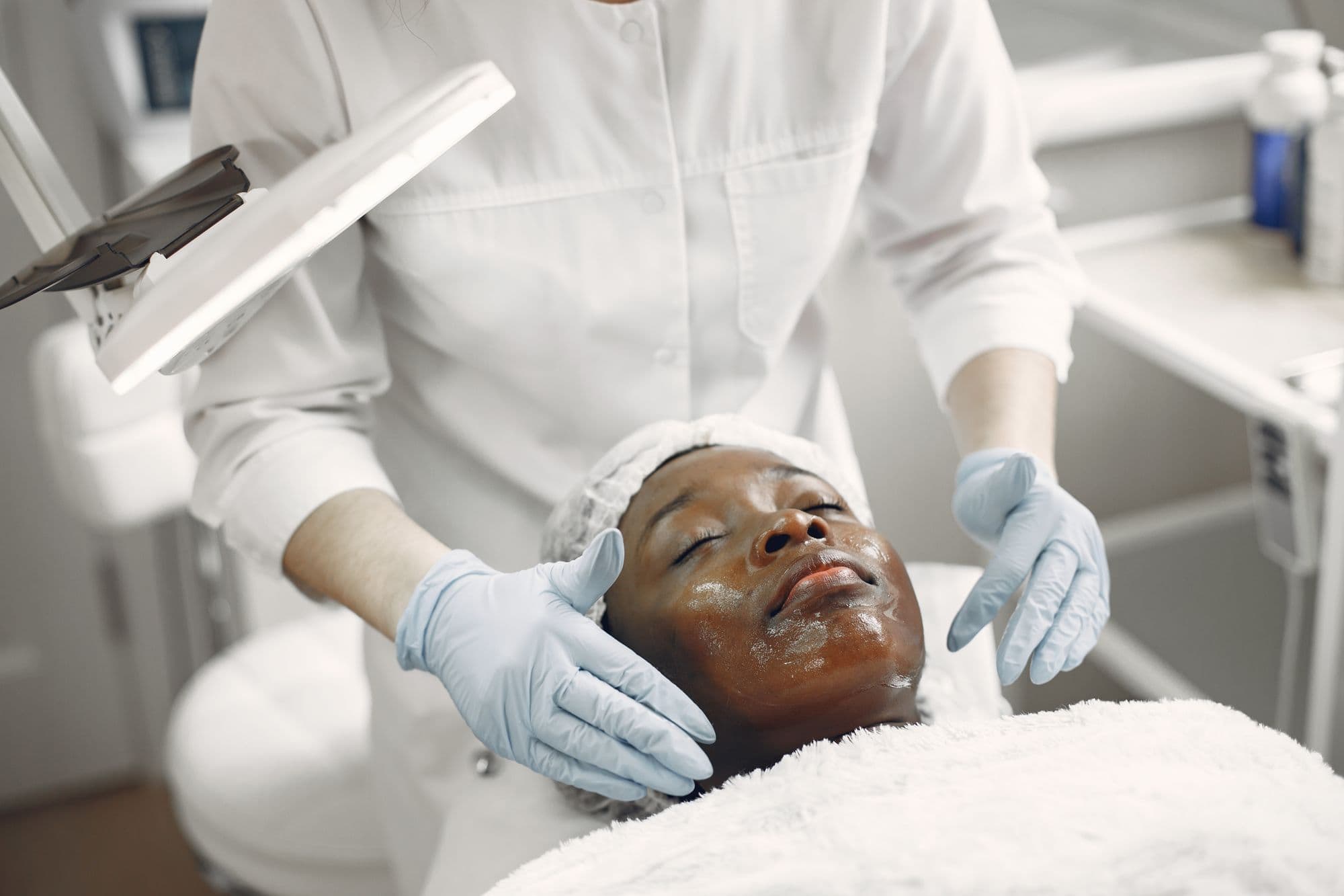 Client relaxing during a professional facial in a bright skincare clinic