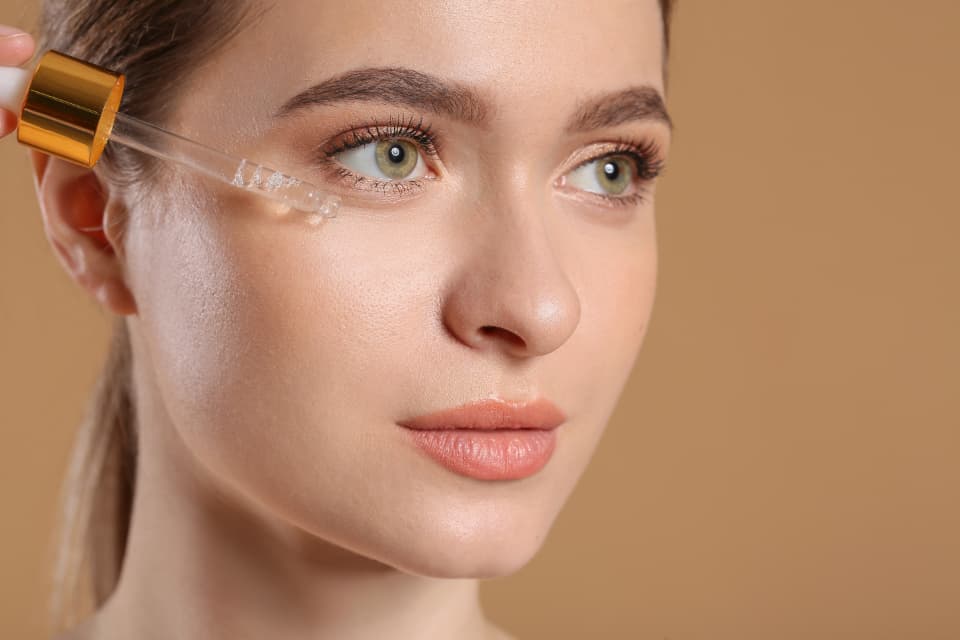 Woman applying serum with a dropper