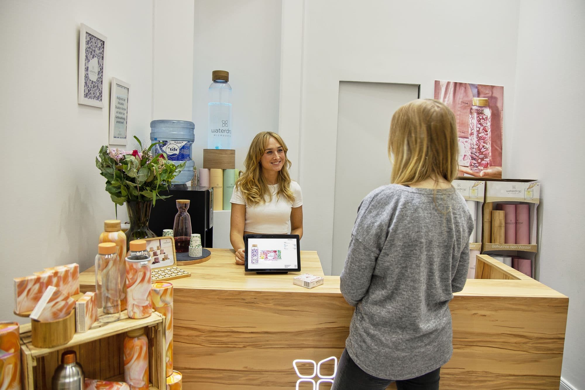Smiling receptionist welcoming a client at a bright studio front desk
