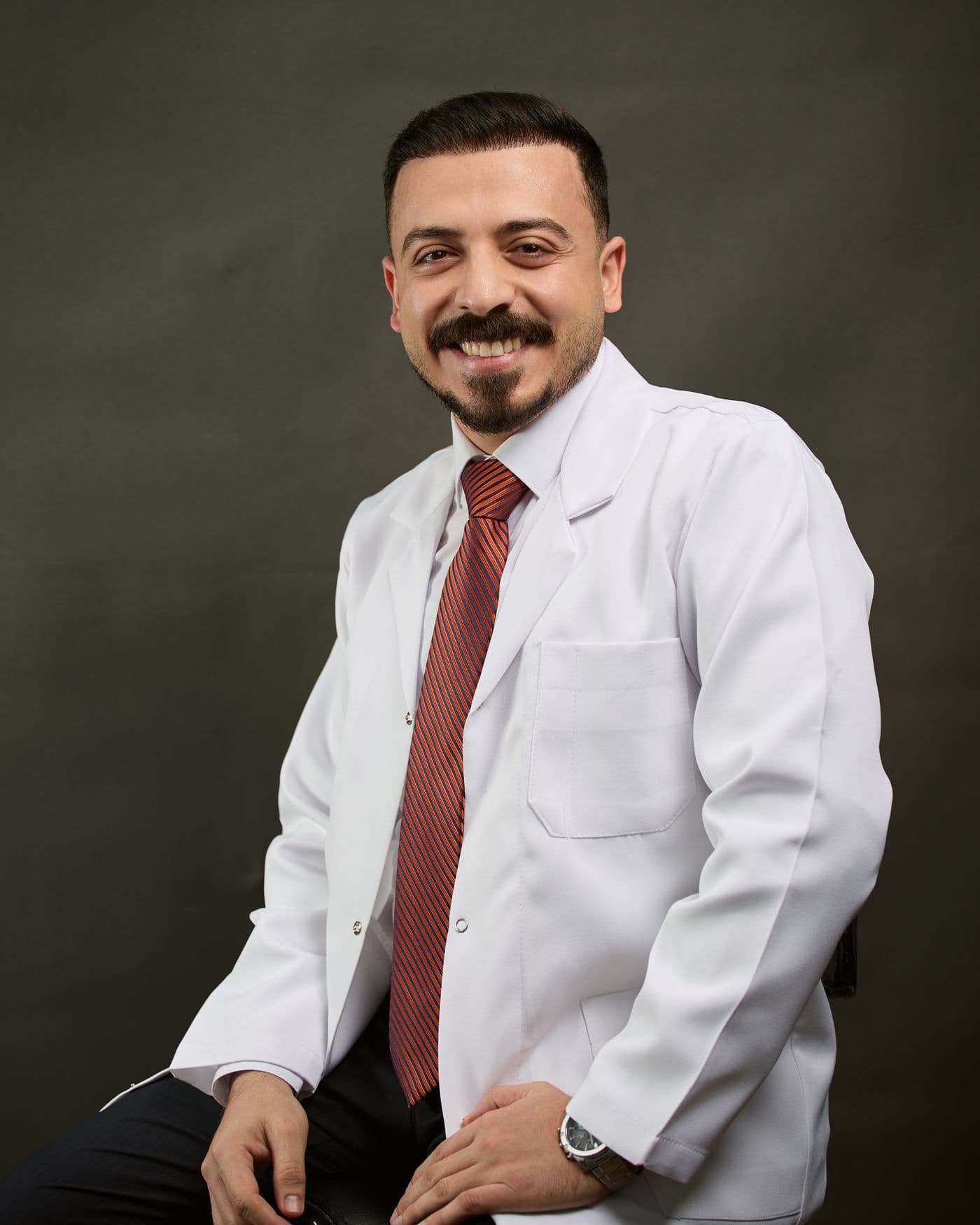 Dr. Marcus Reyes smiling in a white coat